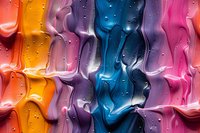 Colorful abstract background with water drops on glass surface creating vibrant streaks in orange, purple, blue and pink tones. Macro photography of condensation pattern.
