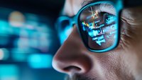 Professional programmer analyzing code on computer screen with data reflection in glasses for software development and technology projects.