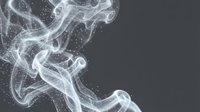 Abstract white smoke and particle effects swirl across dark gray background, creating ethereal flowing motion with glowing sparkles for design overlays.