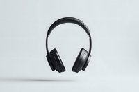 Modern black wireless headphones floating against white background, minimalist studio photography showcasing premium audio equipment for music and entertainment.