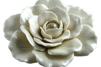 Elegant white ceramic rose flower with layered petals on transparent background, isolated decorative element for crafts and design projects.