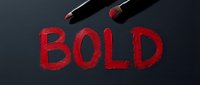 Two red lipsticks with bold strokes creating the word BOLD on dark background. Cosmetics and makeup concept for beauty, fashion, and design projects.