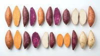 Colorful sweet potato varieties sliced in half displaying vibrant orange, purple, white flesh arranged in rows on white background for healthy cooking.