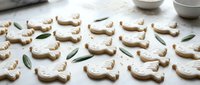 Homemade gingerbread cookies shaped like cute rabbits with white icing decoration arranged on parchment paper, perfect for Easter baking and spring celebrations.