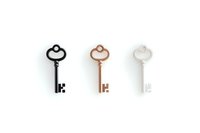Vintage skeleton keys in black, rose gold and white metallic finishes arranged in minimal row composition on white background, isolated design element.