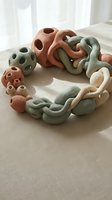 Modern ceramic sculptural objects in earthy tones arranged on neutral fabric surface for contemporary home decor and artistic display.