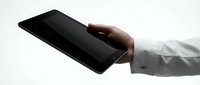 Male hand in white shirt sleeve holding black smartphone with blank screen on white background.
