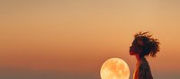 African American woman silhouette against golden sunset sky with full moon rising over ocean horizon creating dreamy atmospheric scene for wellness content.