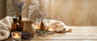 Relaxing spa aromatherapy setup with lavender essential oils, burning candles and natural towels on wooden table for wellness and self-care rituals.
