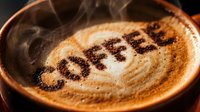 Steaming hot cappuccino with the word coffee written in cocoa powder on creamy froth, close-up shot in a rustic ceramic cup.