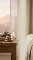 Peaceful spa wellness scene with stacked zen stones, burning candle and lavender on rustic wooden table in serene bedroom setting for relaxation and mindfulness.