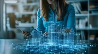 Young Caucasian woman architect using augmented reality visualization of city buildings hologram projection, examining digital urban planning model on modern office desk.