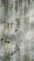 Weathered concrete wall with rust stains and cracks showing aged industrial texture for grunge backgrounds and urban design projects.