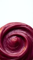 Creamy burgundy swirl texture isolated on white background for cosmetic skincare beauty product design and graphic applications.