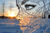 Surreal profile of ice-covered face silhouette against winter sunset, creating ethereal frozen portrait with detailed frost patterns and golden light illuminating crystalline features.