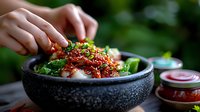 Korean bibimbap bowl with rice, kimchi, vegetables and spicy sauce garnished with sesame seeds and green onions, served in traditional stone bowl.