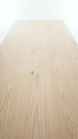 Light wood flooring with natural grain patterns and knots, shot at perspective angle. Suitable for interior design, construction, and home renovation projects.