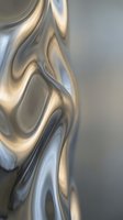 Abstract liquid metal surface with flowing curves and reflective chrome finish for modern design backgrounds.