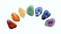 Polished gemstones in rainbow colors arranged in a circle on white background, isolated minerals for jewelry design, healing crystals, and decorative elements.