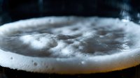 Boiling water with bubbles in metal pot during cooking process. Close-up view of bubbling liquid surface with steam and foam for culinary content.