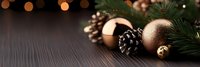 Elegant Christmas ornaments with pine cones and evergreen branches on dark wooden surface with warm bokeh lights creating festive holiday atmosphere.