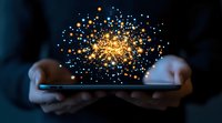 Magical glowing particles burst from smartphone screen held in hands against dark background, creating ethereal light display for digital transformation concept.