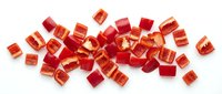 Red and orange translucent cube beads scattered on white background, perfect for jewelry making, crafts and DIY projects. Isolated design elements.