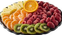 Fresh fruit platter with vibrant sliced orange, kiwi, pineapple and ripe raspberries arranged on dark plate, colorful healthy food composition for catering.