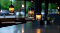 Elegant pendant lights with intricate patterns hanging above dark surface, creating warm ambiance in restaurant interior with blurred background.