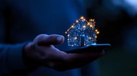 Magical glowing house hologram floating above smartphone in dark environment, sparkling light particles create miniature dwelling shape in palm at night.