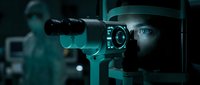 Man in dark hat operating professional video camera with teal lighting, cinematic filmmaking and production technology for movies, documentaries, and broadcast content creation.