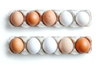 Fresh farm eggs in various natural shades from brown to white arranged in cardboard cartons on white background, top view composition for food photography.