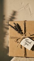 Kraft paper gift box tied with twine and dried lavender, thank you tag, warm sunlight shadows, eco-friendly rustic packaging for holidays.