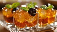 Refreshing amber cocktails with ice cubes, fresh mint leaves and dark cherries served in elegant glasses on silver tray for bar service.