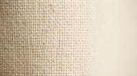 Neutral beige woven fabric texture with soft gradient transition from textured weave to smooth surface, suitable for backgrounds and design projects.