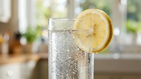 Glass of sparkling water with fresh lemon slice garnish, refreshing beverage for healthy lifestyle, wellness, hydration, and summer drink concepts.