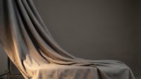 Elegant flowing fabric drapes with soft lighting creating dramatic shadows and highlights on neutral background for luxury interior design concepts.