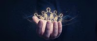 Glowing human figures resting on an open hand against dark background, symbolizing teamwork, unity, support, and community connection for business concepts.