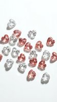 Heart-shaped gemstones in pink and clear colors scattered on white background, luxury jewelry design elements for romantic occasions and gifts.