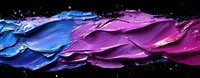 Vibrant blue and purple paint strokes create dynamic waves against black background, artistic macro photography showing texture and movement in flowing colors.