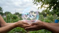 Hands protecting holographic globe with recycling symbol representing environmental conservation and sustainable development in green nature setting.