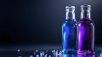Glass bottles with vibrant blue and purple liquid against dark background, condensation droplets creating magical glow effect, dramatic beverage photography.