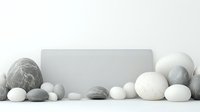 Minimalist composition with gray and white stones arranged around blank rectangle card on light background, zen style arrangement for spa and wellness design.