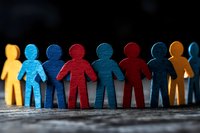 Colorful paper cutout figures holding hands in unity representing teamwork, diversity, inclusion and community collaboration concepts.