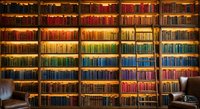 Massive library wall with thousands of colorful books arranged by color creating rainbow gradient effect in academic setting for education concepts.