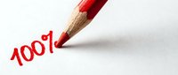Red pencil writing 100 percent symbol on white paper surface for business success and achievement concepts in education and marketing materials.