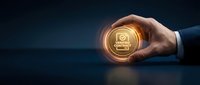 Businessman hand holding glowing quality control icon with gear and checkmark symbol representing certification standards and business excellence processes.