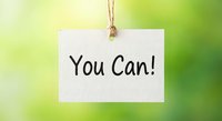 Motivational white paper tag with You Can text hanging on natural twine against soft green blurred background for inspiration and encouragement concepts.