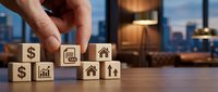 Hand placing wooden blocks with financial and real estate icons on office desk with city skyline background for investment planning concepts.