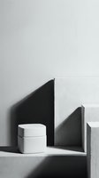 Minimalist black and white cosmetic cream jar on concrete podium with geometric shadows, skincare product display concept.